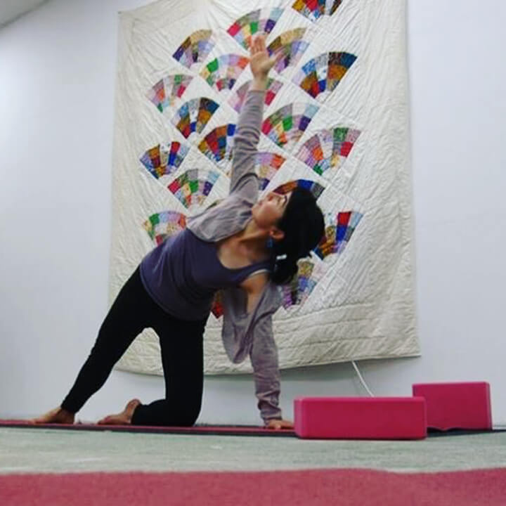 Eine Yogalehrerin zeigt eine Pose in ihrem Pop-Up-Yogastudio